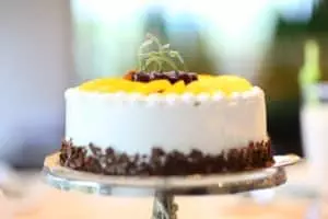 A beautiful white cake with yellow and gold fruit