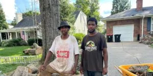Allen and Allen jr of Good News Tree Service cutting down a tree